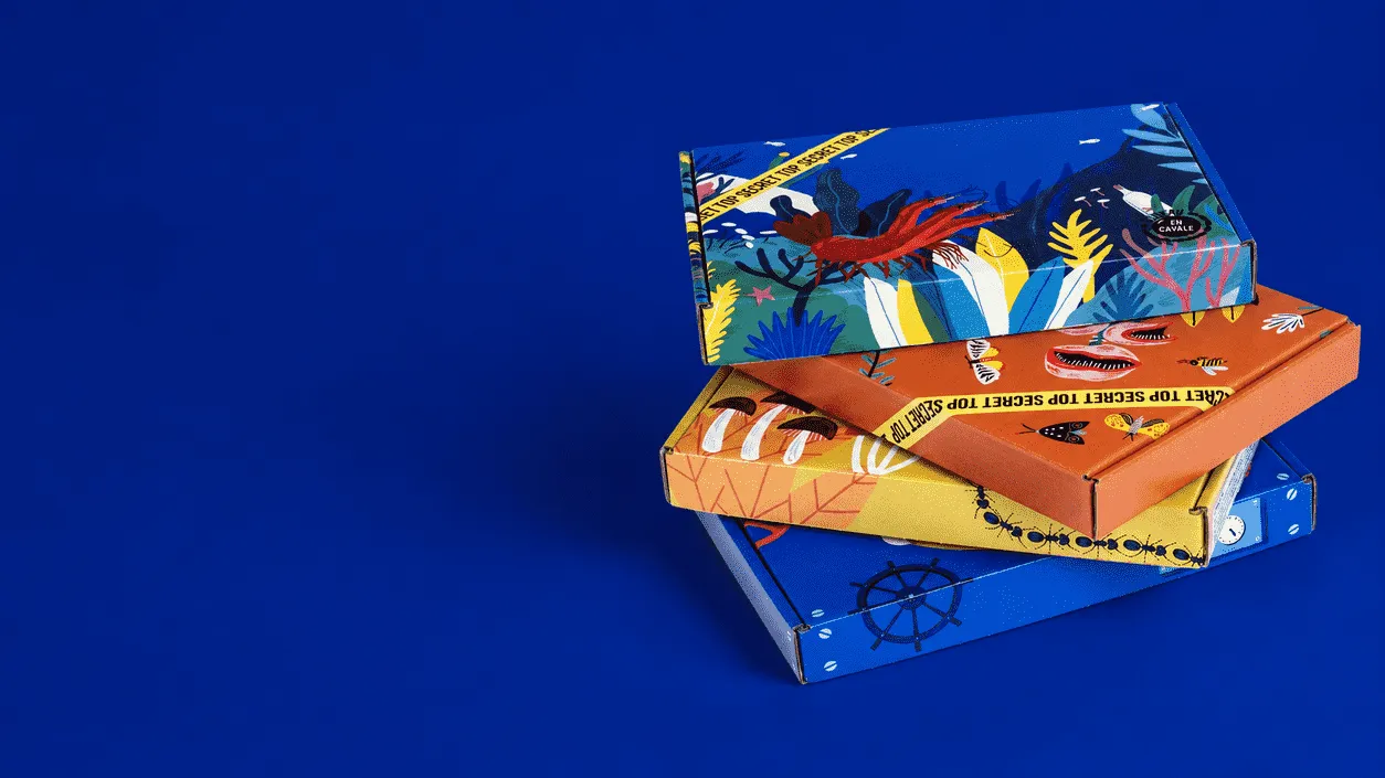 Quatre boîtes postales En Cavale empilées, chacune illustrée d'un design différent, sur fond bleu