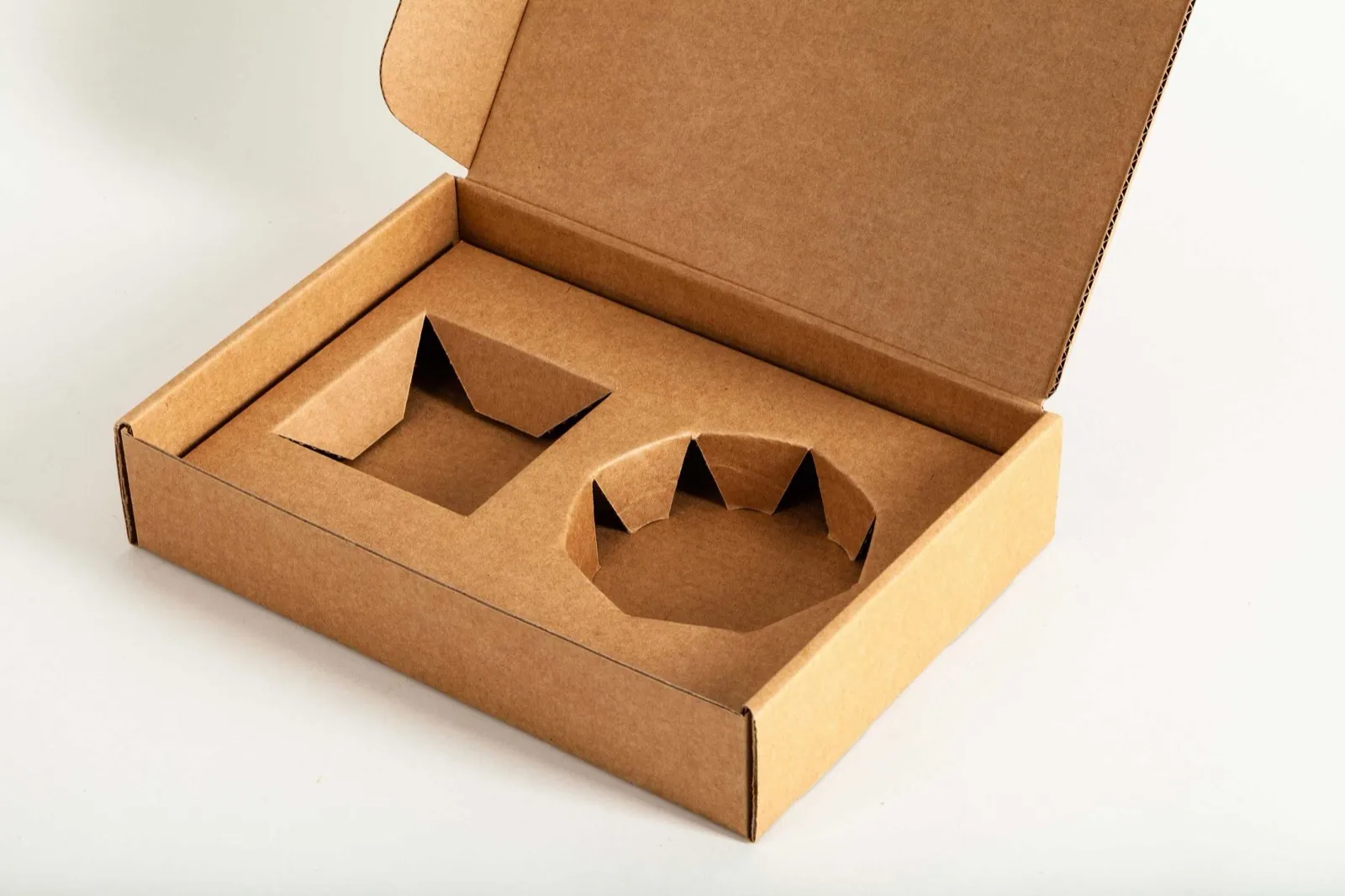 Calage carton découpé avec faux fond et rembord dans une boîte kraft